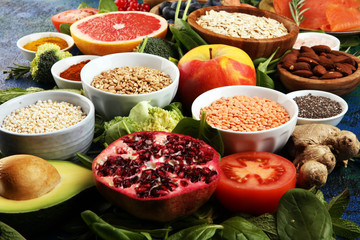 Healthy food clean eating selection: fish, fruit, vegetable, cereal, leaf vegetable on rustic background