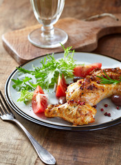 Grilled chicken pieces with fresh salad. Wooden background.