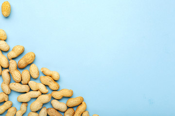 Frame made of nuts peanuts in shell with copy space on blue colored background. Flat lay with place...