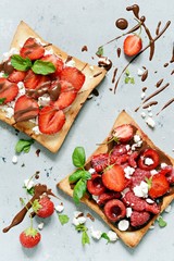 Toast with strawberries, raspberries, cherries, mint and cottage cheese for breakfast. Healthy breakfast, Ruddy bread toast. Traditional American and European summer breakfast: sandwiches of toast 