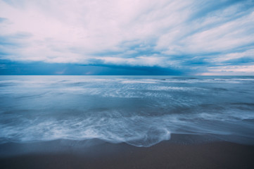 Storm approaching a beach during winter season, long exposure creating water motion,