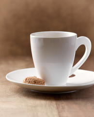 Amaretti and a cup of coffee on brown wooden background. 