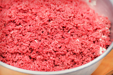 Minced meat. Advertising of fresh minced meat in minced meat close up.  Chopped meat through manual meat grinder close-up. Copy space on the background of minced meat.