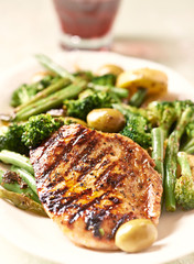 Grilled Turkey Breast with oven baked broccoli and green olives. Bright wooden background.