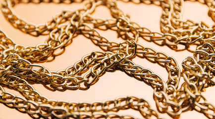 Shiny golden chains on reflective surface