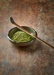 Matcha Powder and Bamboo Scoop on a rustic background.