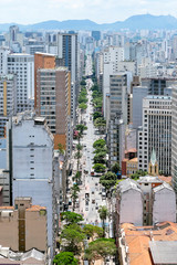 Fototapeta premium Big city with tall buildings and a large avenue with trees. Aerial view of the Avenida Sao Joao avenue at Sao Paulo SP Brazil, the historic downtown of the city.