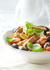 Penne pasta with fried pork tenderloin, cherry tomatoes and black olives.