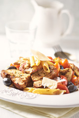 Penne pasta with fried pork tenderloin, cherry tomatoes, black olives and hard cheese. 