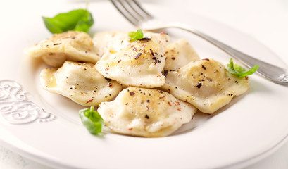 Dumplings with potato and cottage cheese stuffing (pierogi). Traditional Polish Christmas Dinner. Bright background.