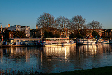 Fototapeta na wymiar Boats and barges on the River Thames at Kingston-Upon-Thames at dusk