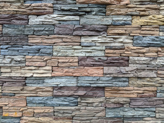 Multi-colored masonry: the wall of the house is made of decorative stone. Beautiful background for design and banners
