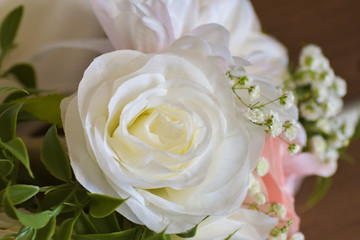 closeup of a bloomed white rose standing out in a floral arrangement on a wedding day