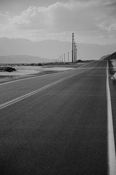 Black and white desert road with powerlines 