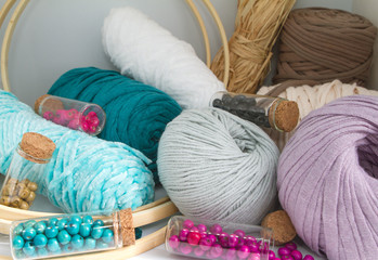 Fototapeta na wymiar Balls of yarn, wool, rope and beads of earth blue and white colors.