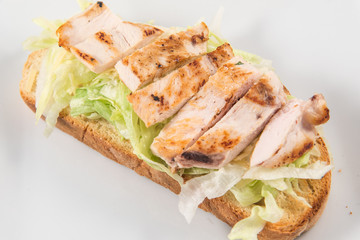 Caesar salad toast with lettuce and chicken slices