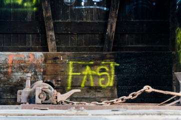 Fast word written with yellow spray paint inside abandoned train car