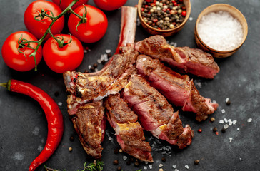 steak - sliced ​​grilled beef tomahawk with spices on a stone background. with copy space for your text