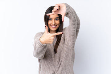 Young brunette woman over isolated white background focusing face. Framing symbol