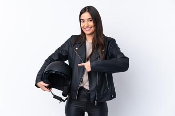 Young brunette woman with a motorcycle helmet over isolated white background and pointing it
