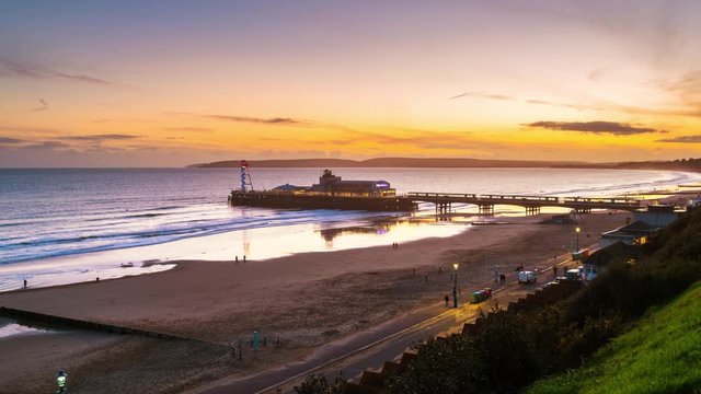 Bournemouth, UK. Aerial view of famous Pier in Bournemouth, England, UK during the sunset. Time-lapse with moving waves of the sea., zoom in