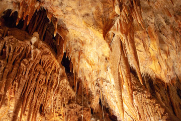 A cave's ceiling with stalactites and a dark deep crack. Yarrangobilly Caves, Kosciuszko National Park, NSW, Australia.