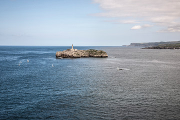 Landscape of a small island with a lighthouse in Cantabria, Spain. Image.