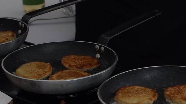 Close-up chef cooking meat cutlets for burger in pan surrounded by boiling oil 4k footage. Male hands in gloves preparing unhealthy fat food at kitchen working at restaurant or cafe