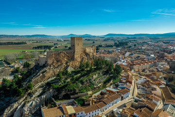 Fototapeta na wymiar Aerial view of medieval Almansa castle with donjon and courtyard on a rock emerging from the plateau surrounded by a circular ring of red roof houses in Spain, site a famous battle