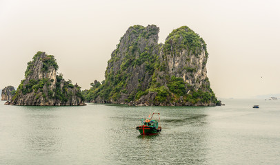 Traditional Vietnamese Sailing Fishing Boat in Bai Tu Long Bay in Halong Bay Vietnam on a Cloudy Day
