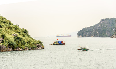 Traditional Vietnamese Sailing Fishing Boat in Bai Tu Long Bay in Halong Bay Vietnam on a Cloudy Day