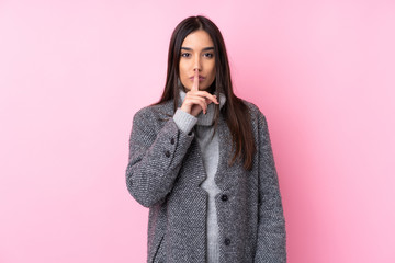 Young brunette woman over isolated pink background showing a sign of silence gesture putting finger...