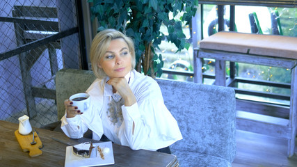 beautiful elegant stylish blond woman resting in a cafe