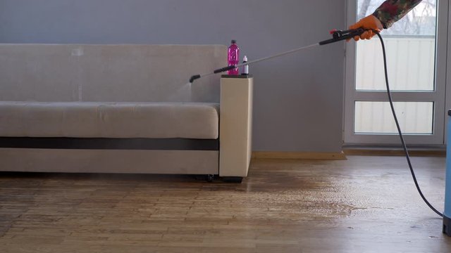 elderly man in special clothes, glasses, mask and apron sprays poisonous substance from container with spray. Two-component poison against bed bugs. Military pensioner ready to fight insects sprayer