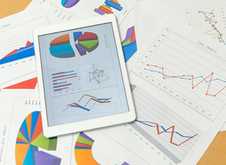 Financial charts on the table with tablet