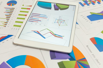 Financial charts on the table with tablet