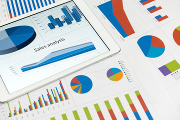 Financial charts on the table with tablet