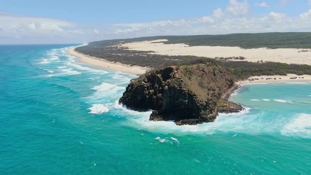 High angle aerial drone footage of famous Indian Head headland which marks both the most easterly point on the island and the northern end of 75 Mile Beach on Fraser Island, Queensland, Australia.