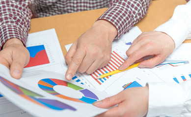 Two businessmen looking at report and having a discussion in office
