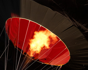 Close up photo of a hot air ballon being inflated at dawn