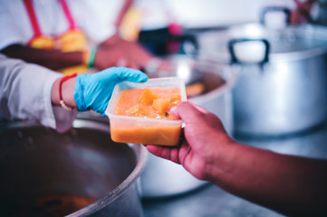 Volunteers donate free charity food to the homeless, the concept of human hunger.