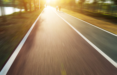 asphalt road with tree lawns under sunshine