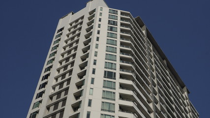 Fototapeta premium Luxury condominium soars ito deep blue sky