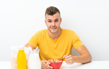 Happy Young blonde man having breakfast