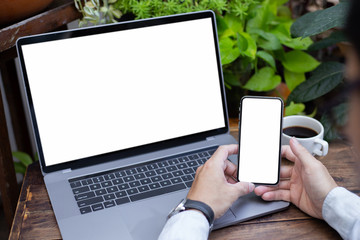mockup image blank screen computer,cell phone with white background for advertising text,hand man using laptop texting mobile contact business search information on desk in cafe.marketing,design