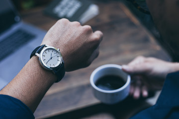 looking at luxury watch on hand check the time at workplace.concept for managing time organization...