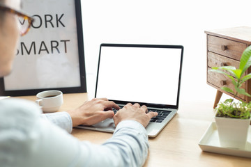 mockup image blank screen computer with blank white background for advertising text,hand man using laptop contact business search information on desk at home office.marketing and creative design