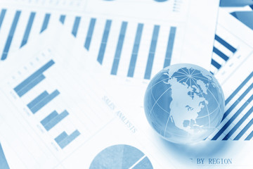 Business presentation with glboe and chart on the desk