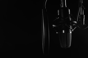 Studio condenser microphone isolated on black. Radio, vocals, podcasts. Copy space.