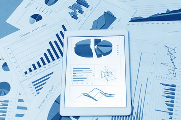 Financial charts on the table with tablet